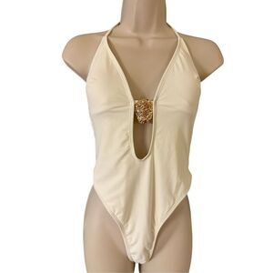 Plunge halter neck thong one piece swimsuit with metal shell medallion cream ivo
